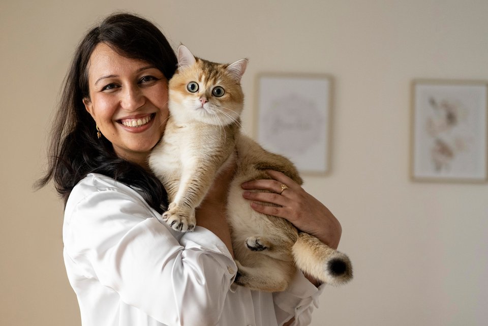 Eine Frau hält lachend eine Katze im Arm und hat keine Angst mehr davor