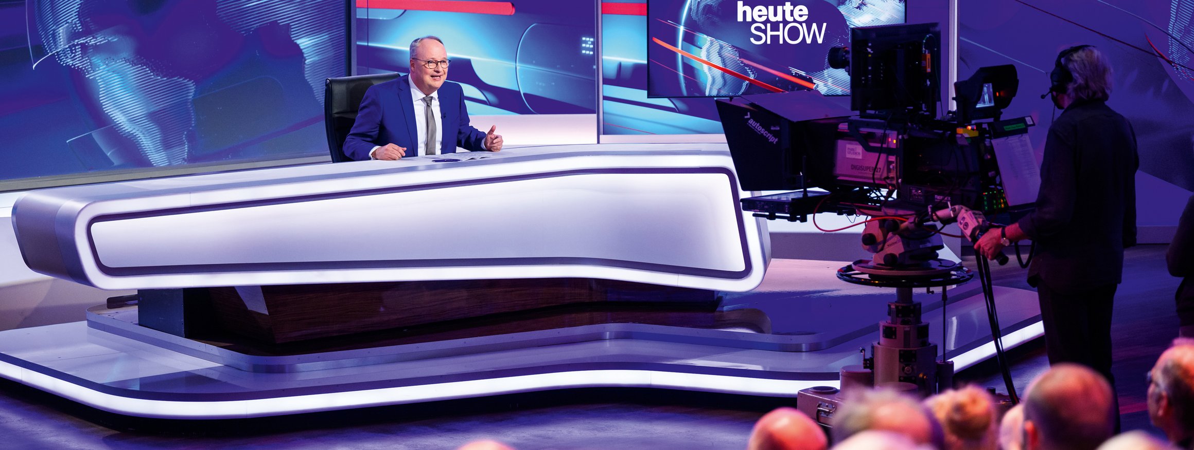 Der Moderator Oliver Welke sitzt in seinem ZDF-Fernsehstudio und moderiert die Heute Show