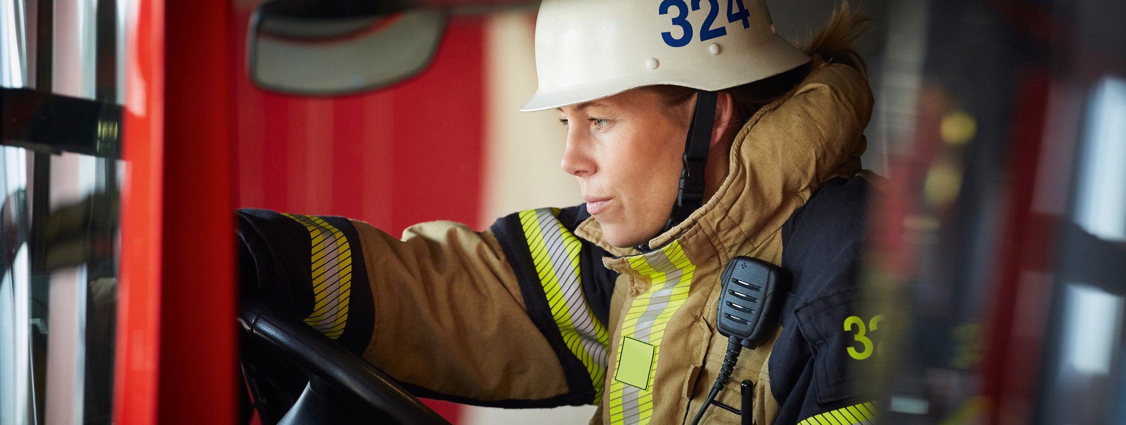 Eine Feuerwehrfrau mit Helm und Schutzkleidung im Einsatz 