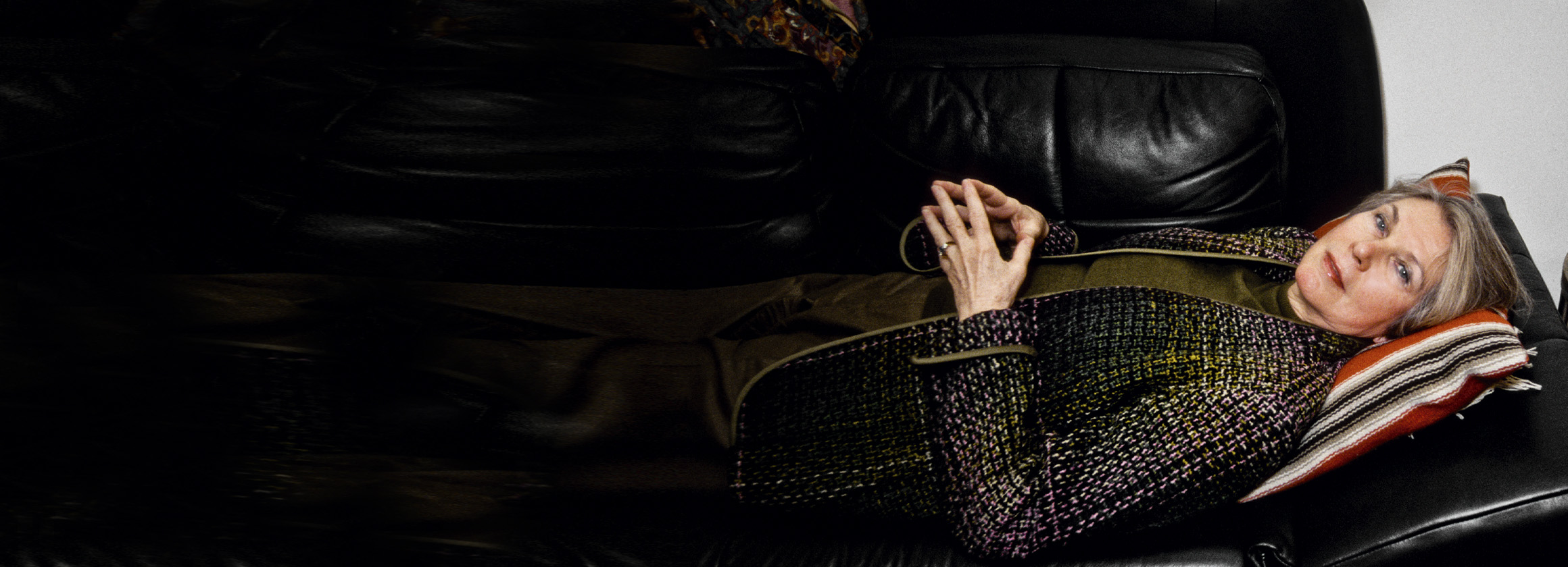 Das Foto zeigt eine Frau mittleren Alters, die klassisch auf einer Couch liegt.